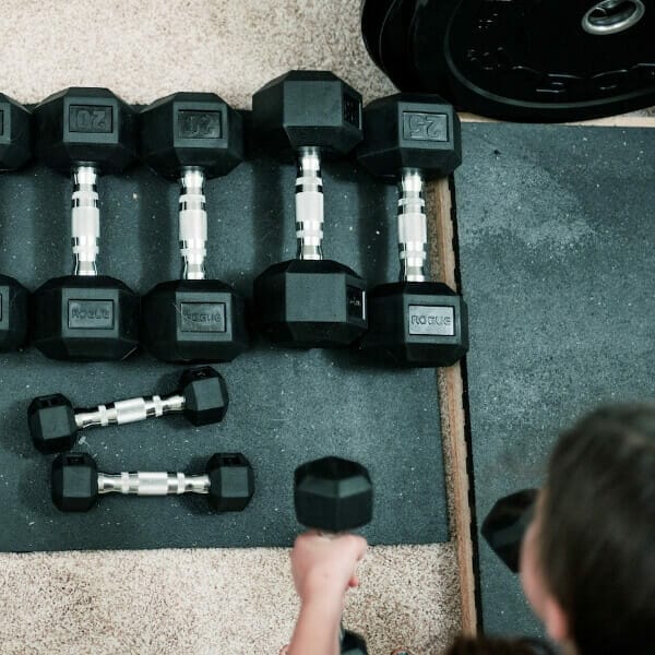 Person selecting dumbbells from the ground
